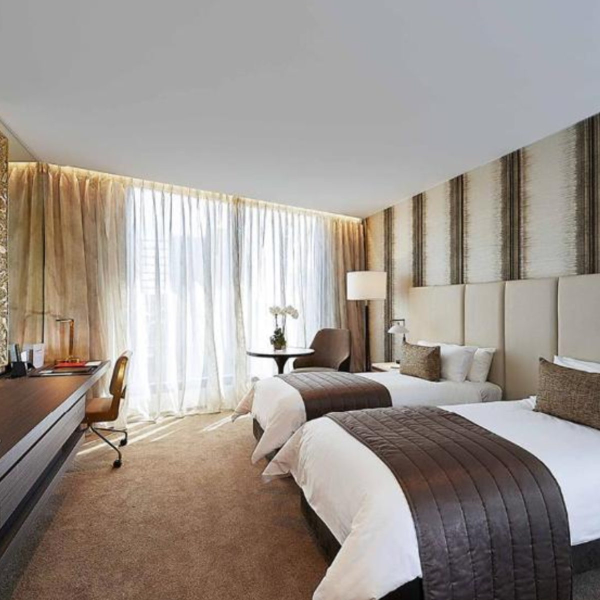 Interior view of Emporium Hotel suite with switchable glass, demonstrating sleek, modern design and spa-inspired ambiance.