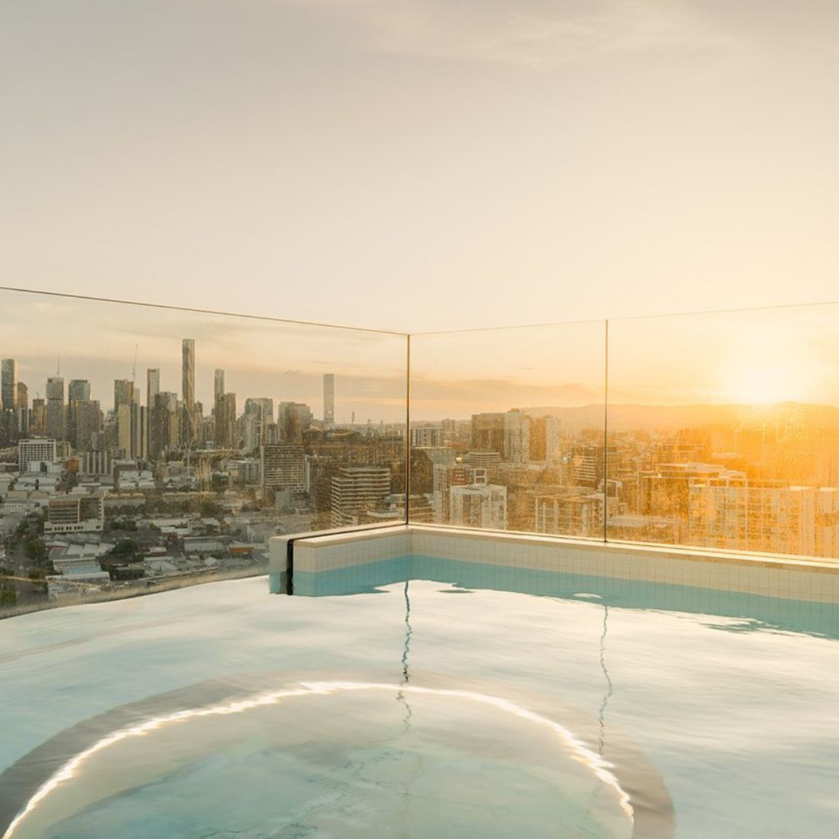 uspended structural glass floor above a swimming pool, featuring low-iron glass, laminated safety layers, and precision commercial glass installation craftsmanship.
