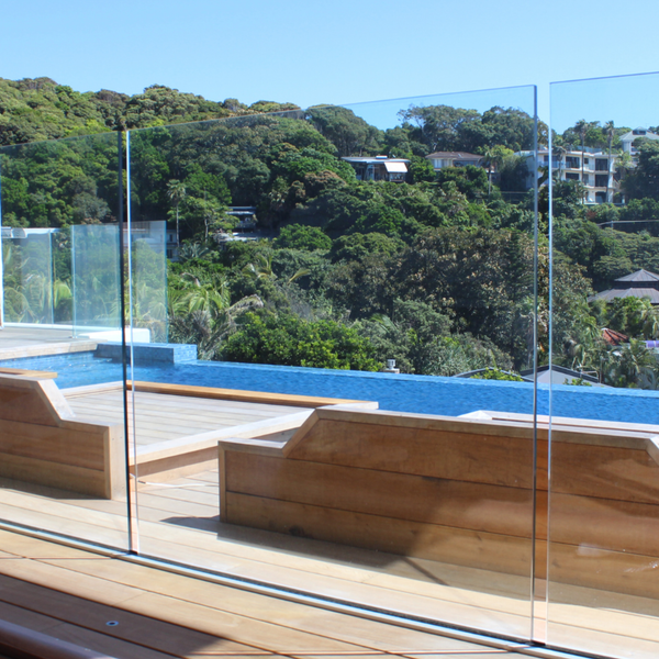 Crystal-clear structural glass balustrade with premium exposed edge finish, seamlessly blending safety, style, and sophistication for a luxurious poolside environment.