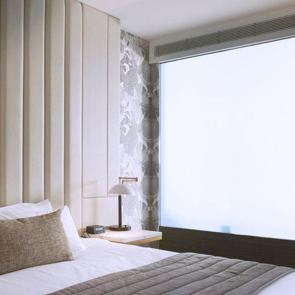 Fixed low-iron switchable glass panel between bedroom and bathroom, highlighting smart glass technology for luxury hospitality interiors.